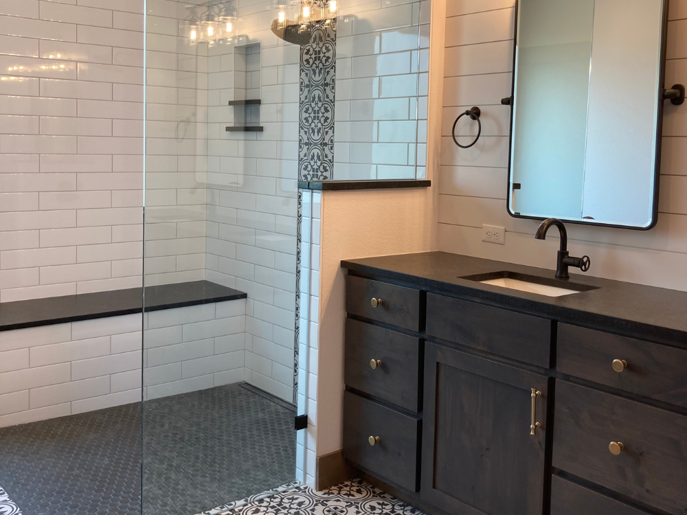 Bathroom with wall tile, walk in shower and dark cabinetry